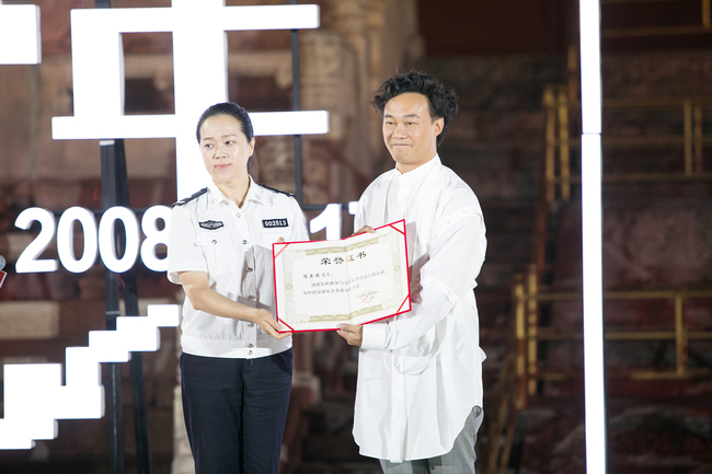 Hong Kong popular singer and actor Eason Chan receives an award for his work in promoting road safety. [Photo provided to China Plus by the event organizer]