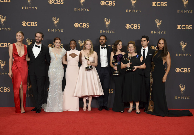 Yvonne Strahovski, from left, Joesph Fiennes, Madeline Brewer, Samira Wiley, Elisabeth Moss, O-T Fagbenle, Alexis Bledel, Ann Dowd, Max Minghella, and Amanda Brugel pose in the press room with their award for outstanding drama series for "The Handmaid's Tale" at the 69th Primetime Emmy Awards on Sunday, Sept. 17, 2017, at the Microsoft Theater in Los Angeles. [Photo: Invision/AP/Jordan Strauss]
