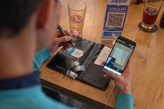 File photo shows a customer pays for his meal through Alipay at a restaurant in Johannesburg, South Africa in August 2017. [Photo: Xinhua] 