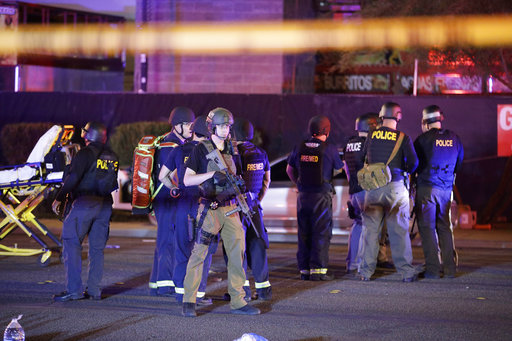 Police officers and medical personnel stand at the scene of a shooting near the Mandalay Bay resort and casino on the Las Vegas Strip, Monday, Oct. 2, 2017, in Las Vegas. [Photo: AP /John Locher]