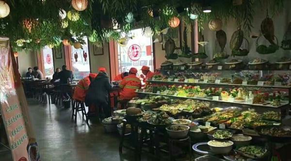 Sanitation workers eat free lunches at Wangluyuan Home Cooking restaurant in Jining, Shandong Province. [Photo: thepaper.cn]