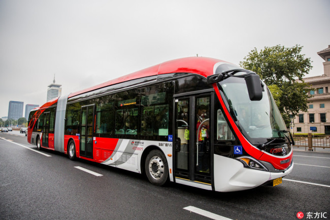 One of the first batch of 10 electric buses in red travels on a road in Beijing, China, 22 October 2017. [Photo: IC]