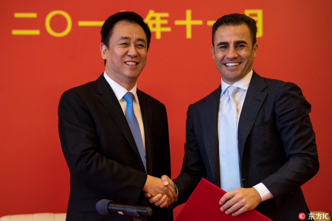 Fabio Cannavaro (R) shakes hands with owner of Guangzhou Evergrande Xu Jiayin at the press conference as he is appointed the head coach of the Chinese Super League club in Guangzhou on Nov 9, 2017. [Photo: IC]