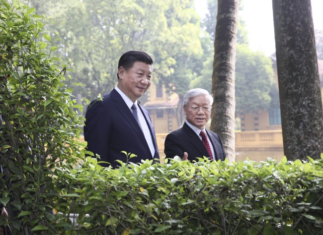 Visiting Chinese President Xi Jinping, who is also general secretary of the Communist Party of China (CPC) Central Committee, and Nguyen Phu Trong, General Secretary of the Communist Party of Vietnam (CPV) Central Committee, go for a stroll at the former residence of late Vietnamese leader Ho Chi Minh in Hanoi, Vietnam, November 13, 2017. [Photo: Xinhua/Lan Hongguang] 