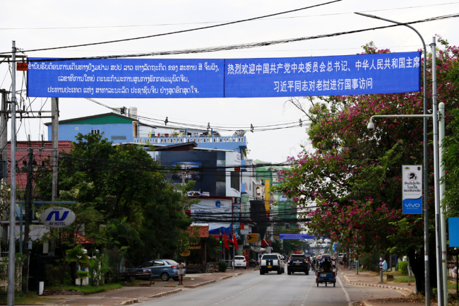 Banners bearing welcome slogans in the Chinese and Lao languages "Warmly welcome the state visit by Comrade Xi Jinping, general secretary of the CPC Central Committee and Chinese president, to Laos," are seen hanging on the main streets in Vientiane, November 13, 2017. [Photo: China Plus/Tu Yun]