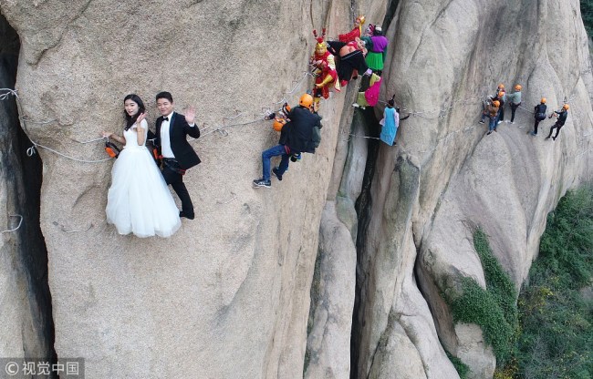惊心动魄的婚纱照！Newlyweds dangled from a cliff for wedding photos