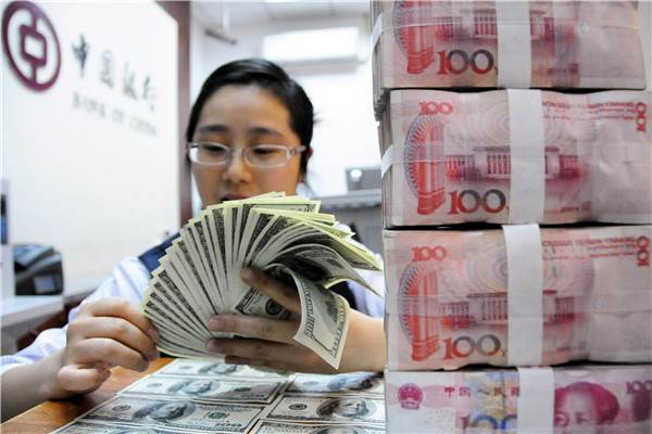 A clerk of Bank of China counts US dollars at a domestic branch. [Photo: Xinhua]