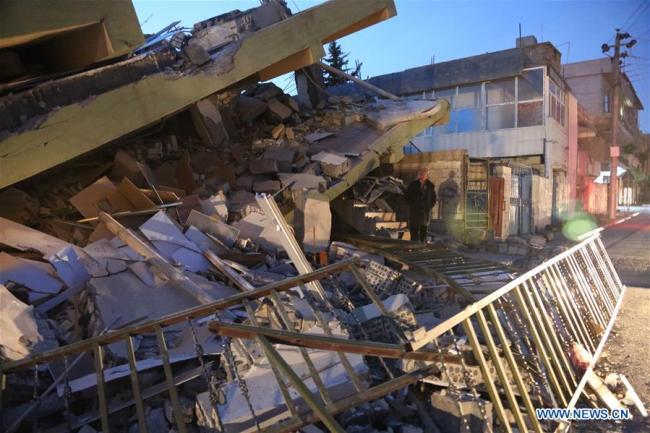 A local resident inspects a collapsed building in the town of Darbandikhan, Sulaimaniyah province, northern Iraq, on Nov. 13, 2017. [Photo: Xinhua]