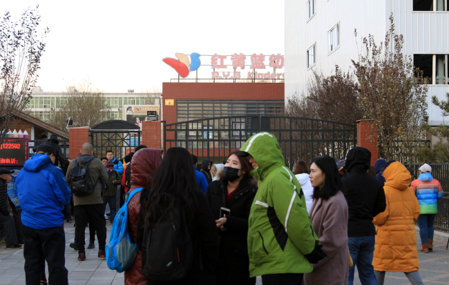 Media and parents gather at the gate of the RYB Education Kindergarten after parents accusing RYB Kindergarten of abusing their children in Beijing, November 23, 2017. [Photo: IC]