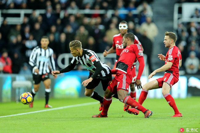 Christian Kabasele (27) of Watford lunges in to win the ball from Dwight Gayle (9) of Newcastle United during the Premier League match between Newcastle United and Watford at St. James's Park, Newcastle, England on 25 November. [Photo: IC]