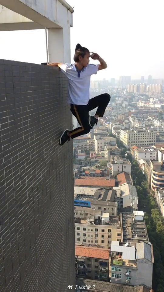 Wu makes a "Monkey King" gesture with one hand clinging to the edge of a high building. [Photo: sina.cn]