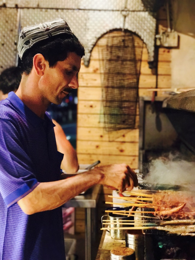 Abdulla is grilling. Although he is the owner of the restaurant, he often works as a regular crew member. He says he can make friends with his customers by serving them. [photo: from China Plus]    