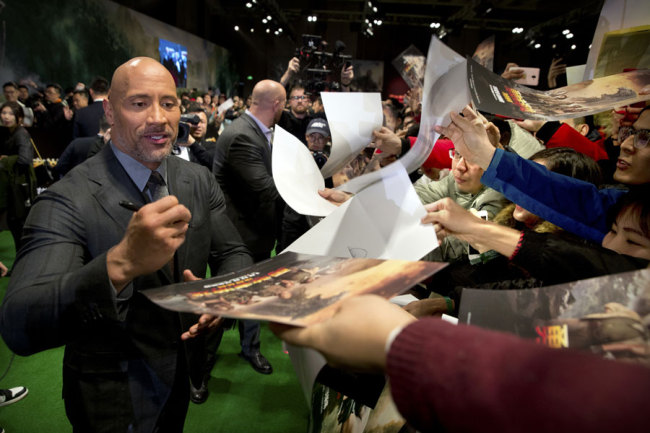 American actor Dwayne Johnson signs autographs for Chinese fans before a press conference for the movie 'Jumanji: Welcome to the Jungle' in Beijing, Thursday, Jan. 4, 2018. The hit movie opens in China on Jan. 12. [Photo: AP/Mark Schiefelbein]