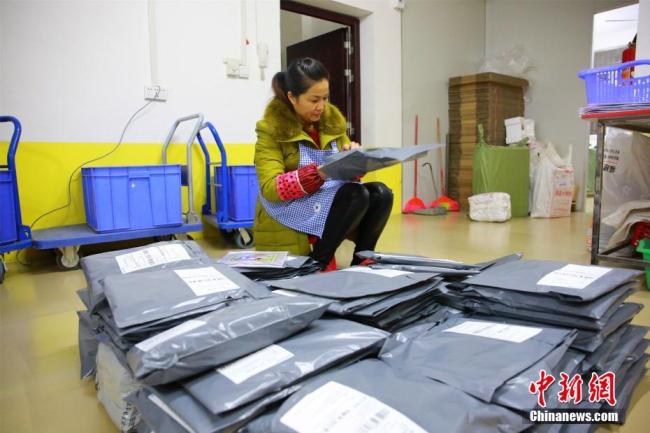 A worker packs deliveries in Jilong Village on January 6, 2018. [Photo: Chinanews.com]