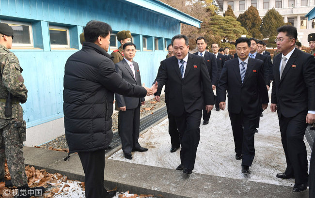Head of North Korean delegation Ri Son Gwon, Chairman of the Committee for the Peaceful Reunification of the Country (CPRC) of DPRK, is greeted by a South Korean official as he crosses a concrete border to attend their meeting at the truce village of Panmunjom in the demilitarised zone separating the two Koreas, South Korea, January 9, 2018. [Photo: VCG]