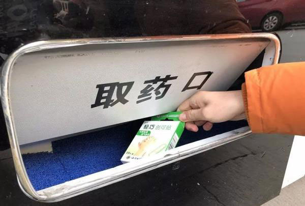A patient collects medicine dispensed by the vending machine. [Photo: thepaper.cn]