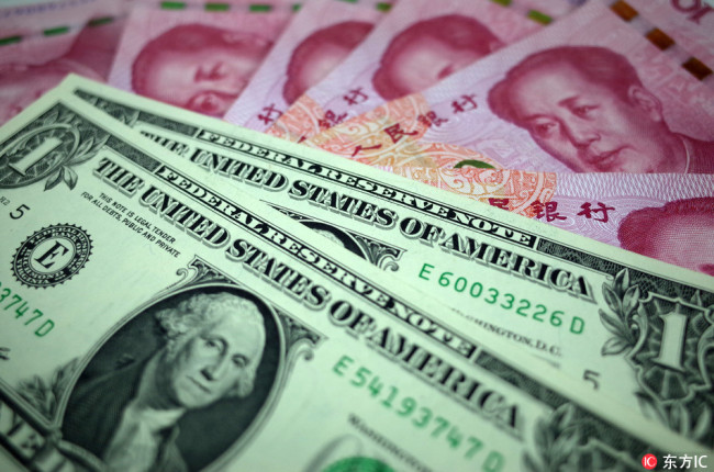 US dollar banknotes over RMB (renminbi) yuan bills. [File Photo: IC]