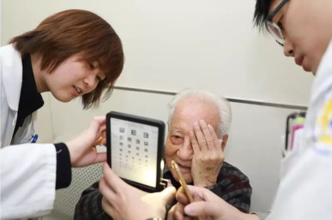 Huang Xuhua, the 93-year-old engineer behind China's first nuclear submarine, takes an eye exam. [Photo: Guangming Daily]