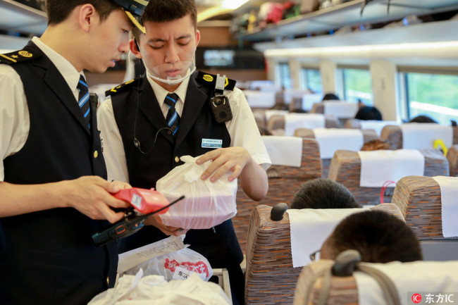 Railway staff deliver the meal to the seat designated by the passenger who orders food online on a high-speed bullet train at the Nanjing South Railway Station in Nanjing city, east China's Jiangsu province, 21 July 2017. [Photo: IC]