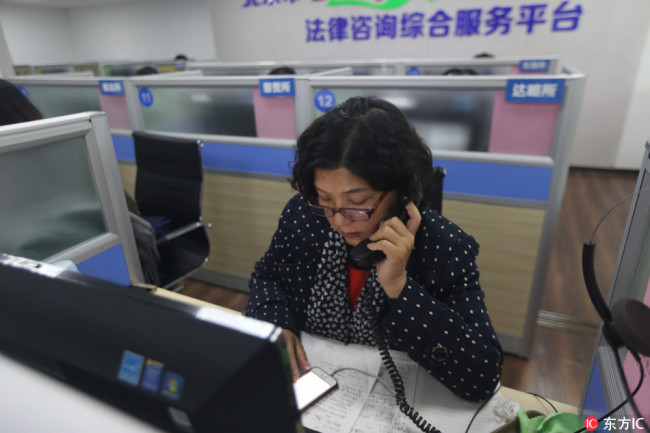A lawyer is answering a counseling hotline at Beijing Legal Assistance Center. [Photo: IC]