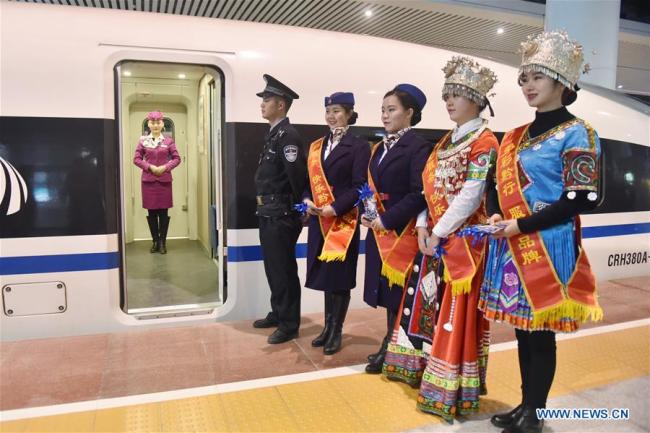 Crew members wait for passengers to board the train at Guiyang North Railway Station in Guiyang, southwest China's Guizhou Province, Jan. 25, 2018. A railway connecting Chongqing and Guiyang, two major cities in southwest China opened on Thursday. Designed for passenger trains running at a speed of 200 km per hour, the 347-km railway will improve traffic between China's southwest and the rest of the country. [Photo: Xinhua]