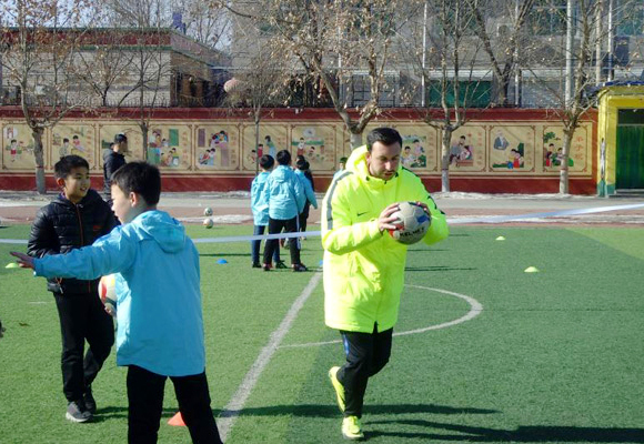 One of the coaches from Football Club Internazionale Milano teaches soccer at Xiongxian No. 1 Primary School in Hebei Province, Jan. 29, 2018. [Photo provided to China Daily]