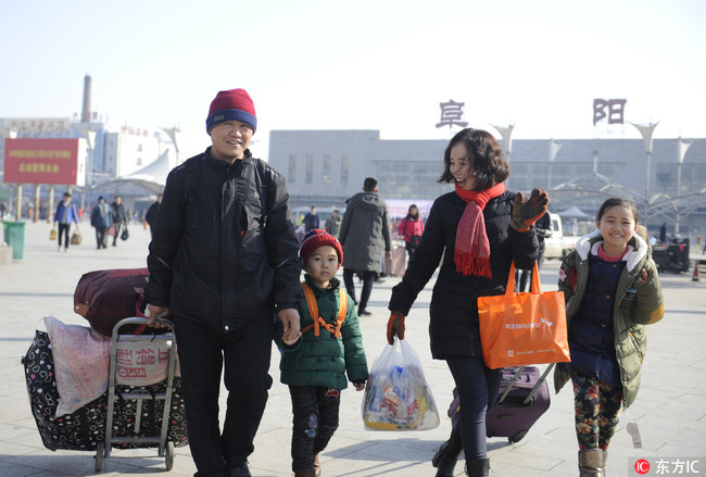 A family leaves Fuyang Railway Station at the end of their journey in Anhui Province on February 1, 2018. [Photo: IC]