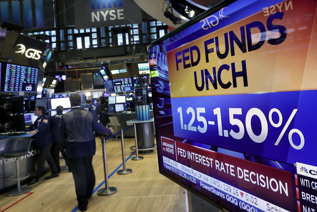 A television screen on the floor of the New York Stock Exchange shows the decision of the Federal Reserve, Jan. 31, 2018. At Janet Yellen's final meeting as chair, the Fed kept its key short-term rate in a still-low range of 1.25 percent to 1.5 percent. [Photo: AP/Richard Drew]