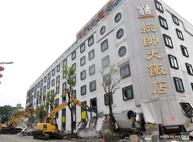 Large machines clear the site of the collapsed Marshal Hotel in Hualien County, southeast China's Taiwan, Feb. 9, 2018. Large machinery started to clear the site of the collapsed Marshal Hotel and two tilted buildings on Friday morning. Rescuers Friday were continuing their search for seven people trapped in a collapsed building about 60 hours after a powerful earthquake struck Hualien. [Photo: Xinhua]