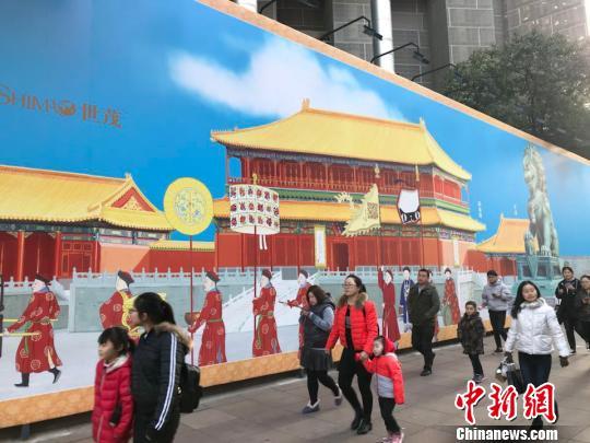 Undated photo shows people walking in front of a Forbidden City-themed mural on Shanghai's famous Nanjing Road. [Photo: Chinanews.com]