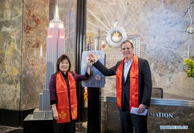 Chinese Consul General in New York Zhang Qiyue (L) and John B. Kessler, President of the Empire State Realty Trust, flip the switch to light the model of Empire State Building at a ceremonial lighting ceremony in honor of the Spring Festival at the Empire State Building in New York, the United States, on Feb. 13, 2018. The top of the Empire State Building in Midtown Manhattan, New York, will shine in red and gold at sunset on Tuesday and Thursday, celebrating the Chinese Lunar New Year that falls on Feb. 16 this year. [Photo: Xinhua]