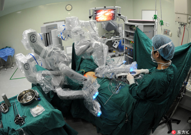 In Chengdu People’s Hospital, a robot doctor was performing surgery for patients, under supervision of human doctor. Photo was taken in November 20, 2014. [photo: from dfic.cn]