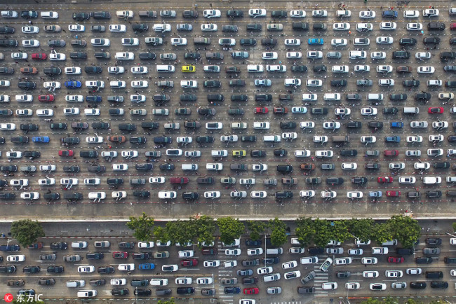 Masses of vehicles line up to wait for ferry services to pass the Qiongzhou Strait on a heavily congested street leading to a port in Haikou city, south China's Hainan province, February 19, 2018. [Photo: IC]