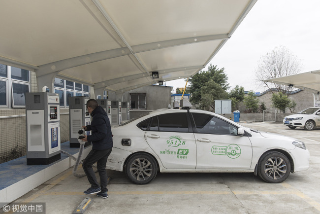 A person charges e-car at an EV-charging station in southeast China's Fujian Province on January 29, 2018.[Photo: VCG]
