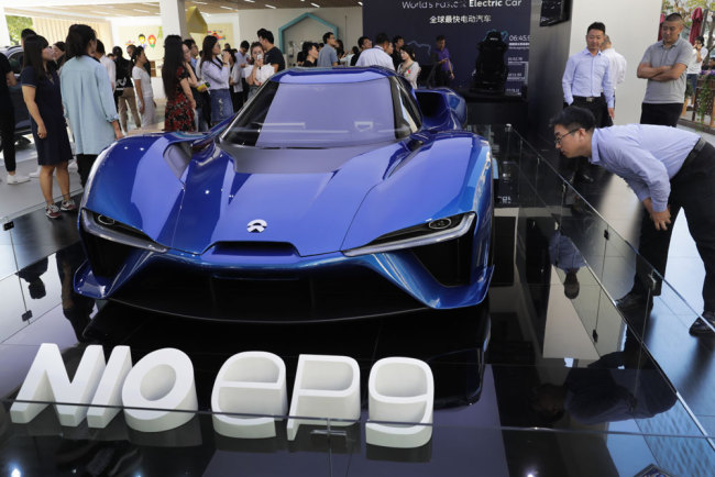 Visitors look at the EP9, an electric-powered supercar manufactured by NIO during a promotion event at a shopping mall in Beijing on September 11, 2017. [Photo: AP]