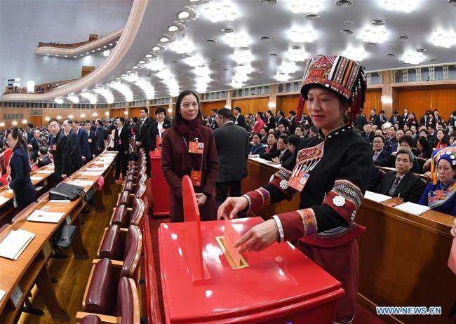 A deputy to the 13th National People's Congress (NPC) casts her ballot on a draft amendment to the country's Constitution at the third plenary meeting of the first session of the 13th NPC in Beijing, capital of China, March 11, 2018. [Photo: Xinhua]