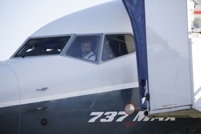 A pilot looks on as a Boeing 737 MAX 7 he prepares for the airplane's first flight, Friday, March 16, 2018, in Renton, Wash. [Photo: AP/Jason Redmond]