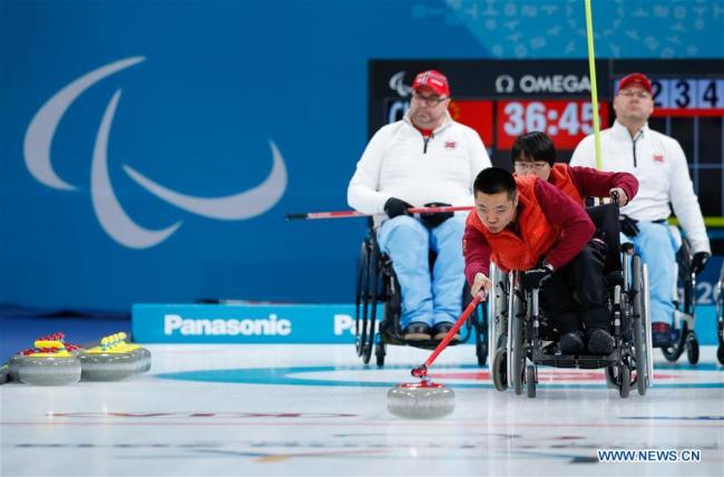 China's Liu Wei (front) competes during the wheelchair curling final against Norway at the 2018 PyeongChang Winter Paralympic Games at Gangneung, South Korea, March 17, 2018. [Photo: Xinhua]