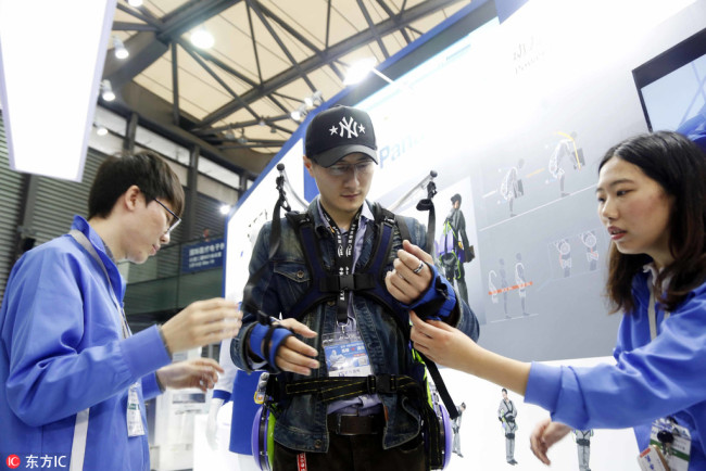 A visitor tries out a robotic exoskeleton during the Electronica China 2018 in Shanghai, China, 15 March 2018.[Photo: IC]