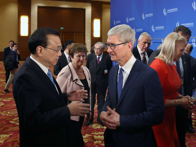 Chinese Premier Li Keqiang (left) speaks with Apple CEO Tim Cook during the China Development Forum in Beijing on March 26, 2018. [Photo: gov.cn]