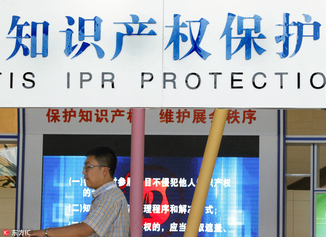 A visitor walks past a signboard of intellectual property rights (IPR) protection during a trade fair in Beijing, China, 29 May 2016.[Photo: IC]