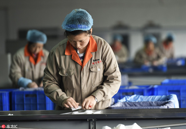 Workers check degradable disposable tableware to be exported to Southeast Asia at a factory in Zouping County, Shandong Province, November 16, 2014. [File Photo: IC]