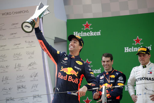 Red Bull driver Daniel Ricciardo of Australia raises his trophy as he celebrates after winning the Chinese Formula One Grand Prix at the Shanghai International Circuit in Shanghai, Sunday, April 15, 2018. At right is Mercedes driver Valtteri Bottas of Finland who finished second.[Photo: AP]