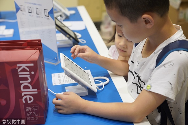 Children read an e-book at a book fair in Shanghai. [File photo: VCG]