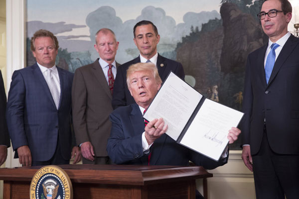 U.S. President Donald Trump signs a memorandum calling for a trade investigation of China, on August 14, 2017, in the Diplomatic Reception Room of the White House in Washington DC. [Photo: Imagine China]