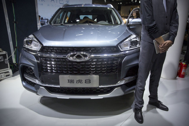A staff member stands next to a Tiggo 8 SUV by Chinese automaker Chery after a press conference at the China Auto Show in Beijing, Wednesday, April 25, 2018. Auto China 2018, the industry's biggest sales event this year, is overshadowed by mounting trade tensions between Beijing and U.S. President Donald Trump, who has threatened to hike tariffs on Chinese goods including automobiles in a dispute over technology policy. [Photo: AP]