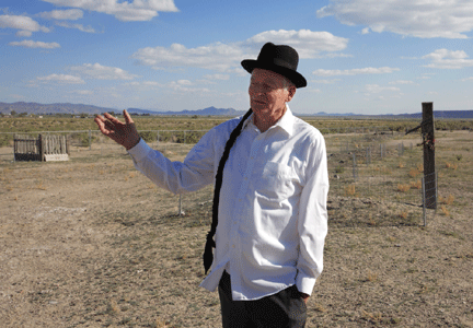Larry De Leeuw, a local resident of Lovelock, stands in front of the deserted Chinese cemetery. De Leeuw, who has a strong interest in Chinese culture,  has voluntarily started to weed, build fences, and do anything he could to preserve the graveyards. Every year, ahead of the Tomb Sweeping Day, which is the traditional Chinese holiday for people to pay respect to their ancestors, he will post ads in newspapers in California and Nevada, calling for Chinese people to visit the graves. [Photo: Li Ju]