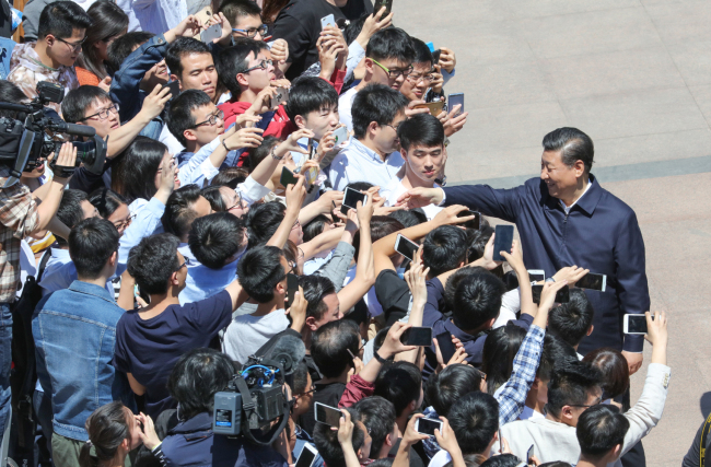 Chinese President Xi Jinping shakes hands with students during his visit to Peking University in Beijing, on May 2, 2018. [Photo: Xinhua] 