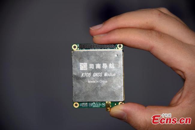 A worker shows radio frequency chip Hengxing-1 at the ninth China Satellite Navigation Conference in Harbin, capital of Heilongjiang province, May 24, 2018. [Photo: Photo: China News Service/ Sunnn Zifa]