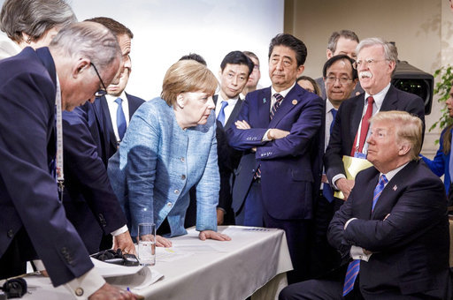 In this photo made available by the German Federal Government, German Chancellor Angela Merkel, center, speaks with U.S. President Donald Trump, seated at right, during the G7 Leaders Summit in La Malbaie, Quebec, Canada, on Saturday, June 9, 2018. [Photo: AP]